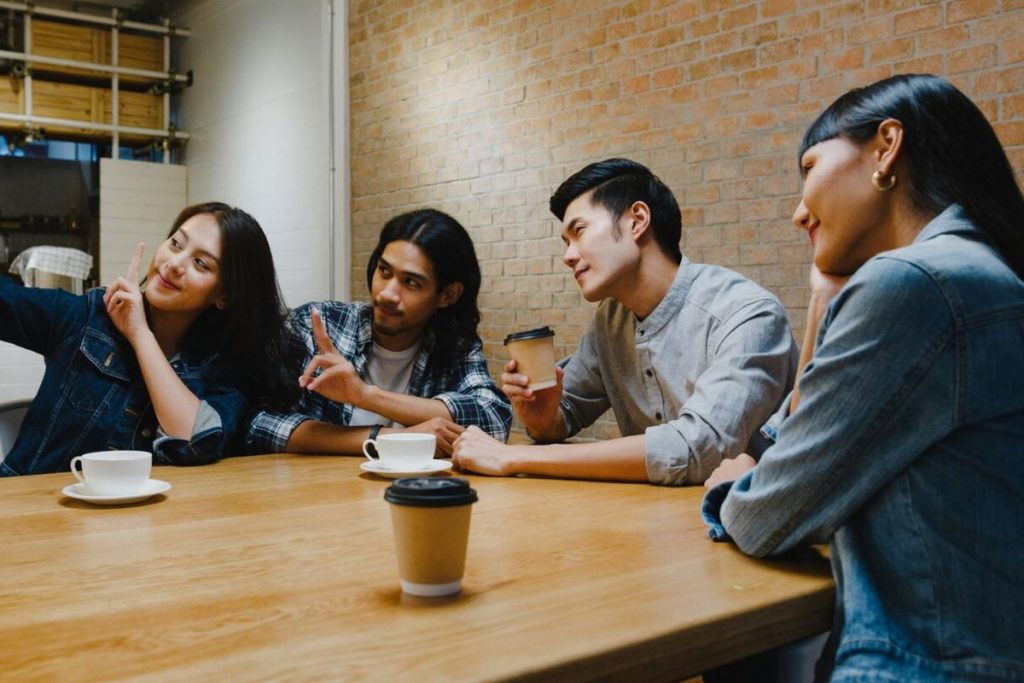 Sekelompok anak muda Gen Z melakukan soft socializing dengan membaca buku dan menikmati aktivitas bersama dalam suasana santai.